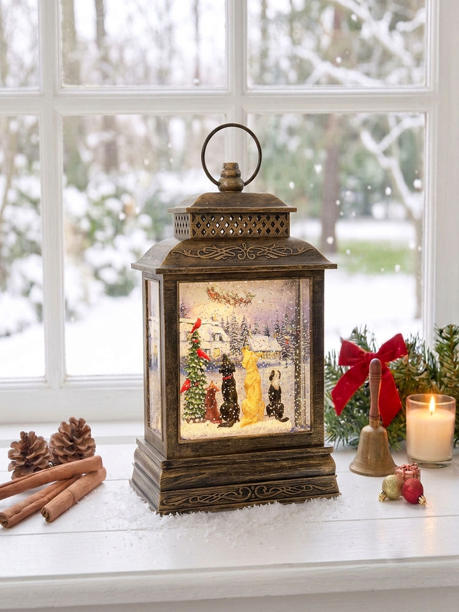 Decorative lantern snow globe with a Christmas scene of dogs watching santa fly away on a windowsill with snow outside.