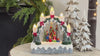 snow globe with carolers set on a table with decorative trees